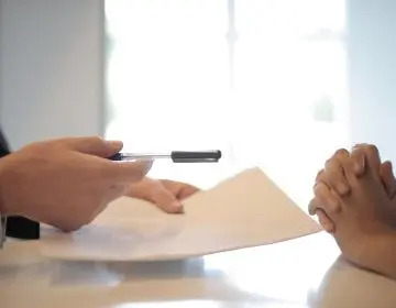 Closeup of two people discussing a document